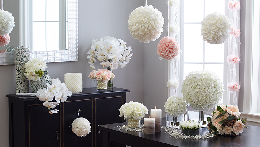 Floral bouquets, hanging floral poms, detailed lace vases and candles decorate this simple table style.